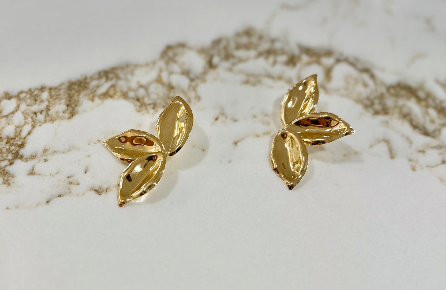 Petals - plated 18k gols hammered gold earrings shaped like flower petals.